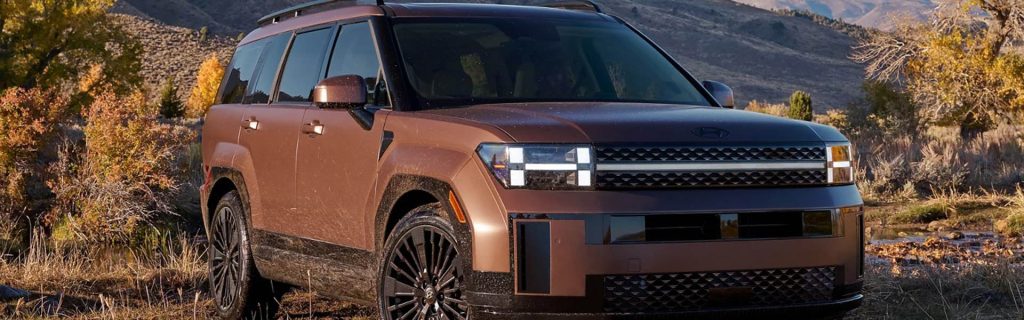 Brown SUV parked near a mountain landscape during an outdoor adventure.
